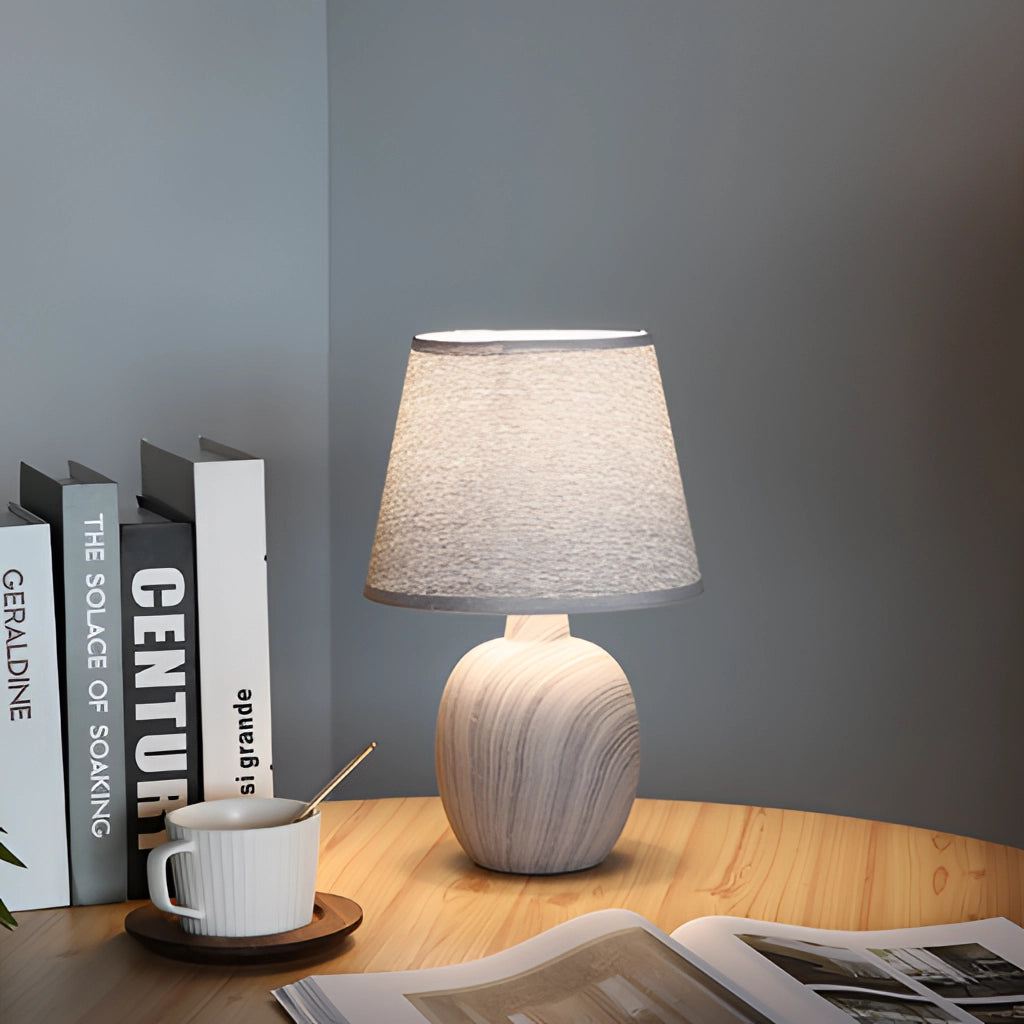 Contemporary rechargeable table lamp with unique style placed on a wooden table in a modern interior with grey flooring.