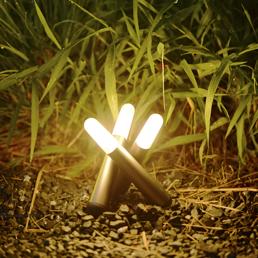 A cordless kinetic rotation LED table lamp placed on a wooden table next to a green plant with grass visible in the background.