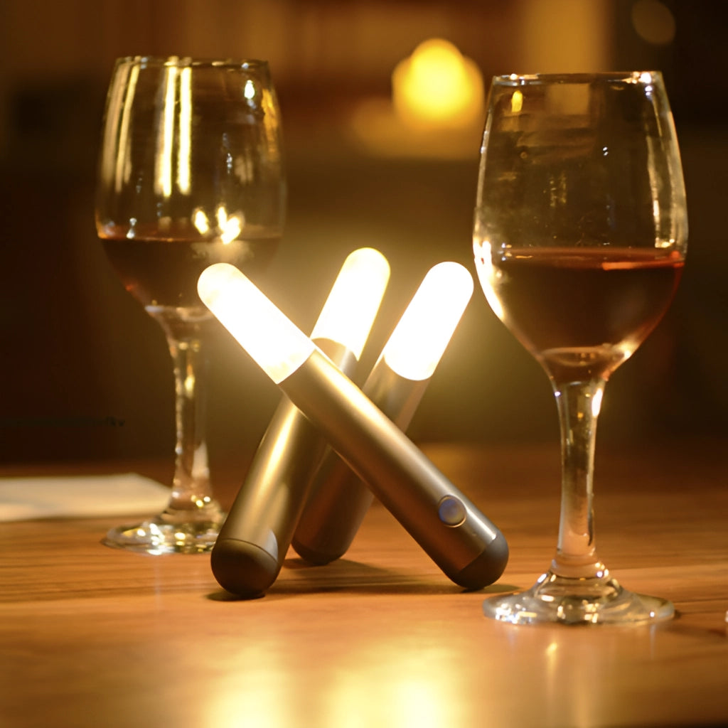 Cordless Kinetic Rotation LED Table Lamp on a table next to a wine glass filled with liquid.