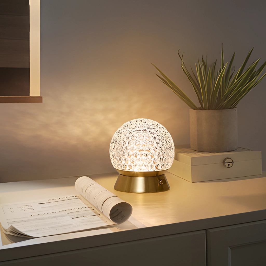 Modern cordless rechargeable table lamp with LED dimmable light on a wooden table next to a flowerpot and houseplant in a stylish interior design setting.