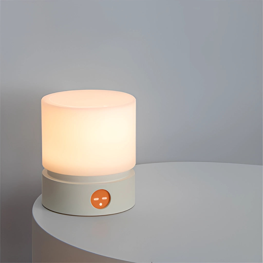 Cordless table lamp with cylindrical shape, featuring adjustable brightness and sleek modern design, illuminated and standing on a rectangular base.