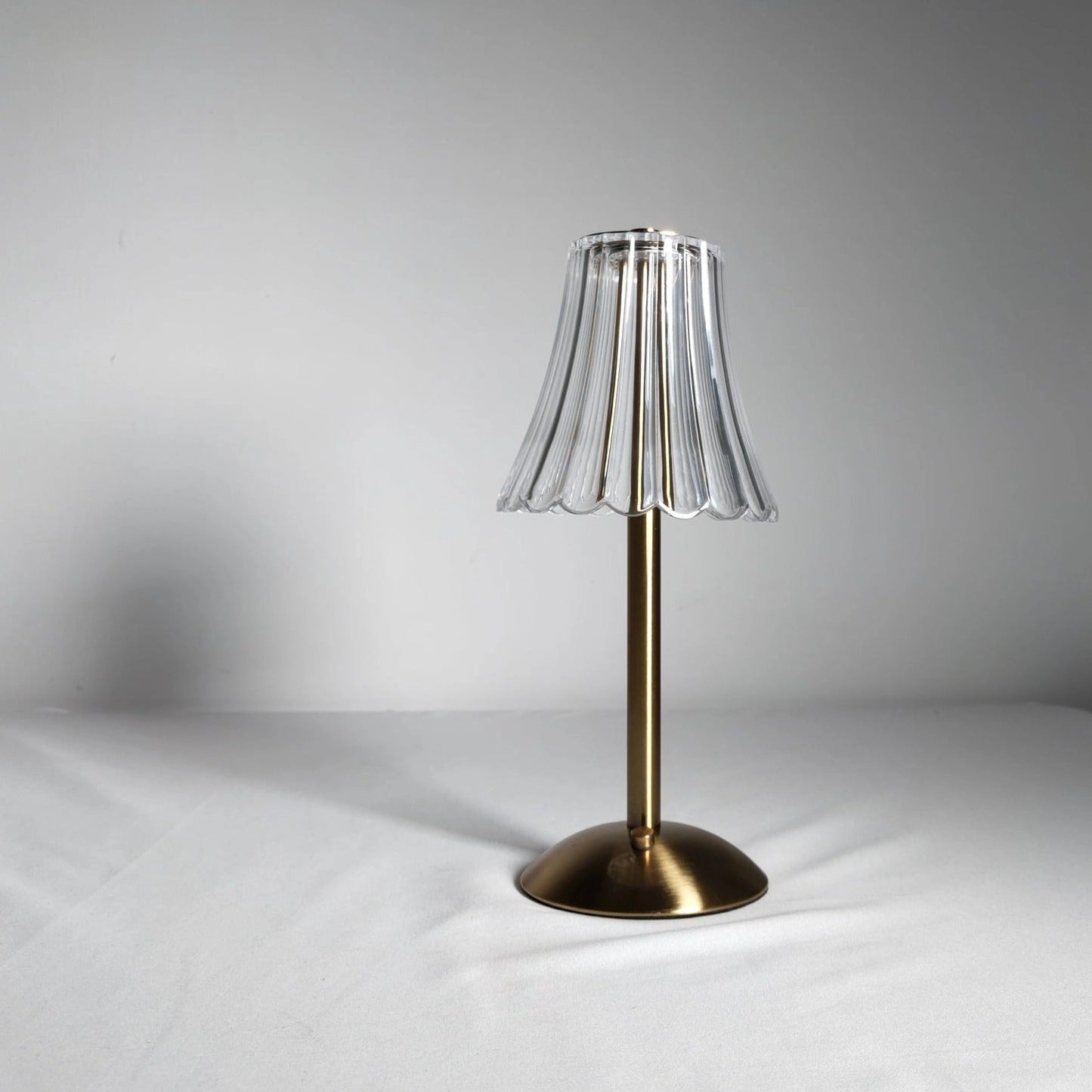 Cordless table lamp with supreme durability and beautiful design, featuring a wooden base, metal accents, and a circular glass shade.