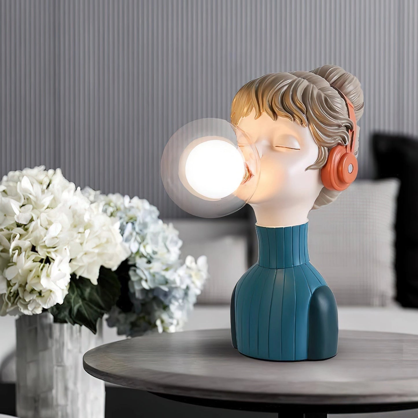 Chic minimalist orange and green desk lamp designed with a resin base, featuring an artificial flower arrangement.