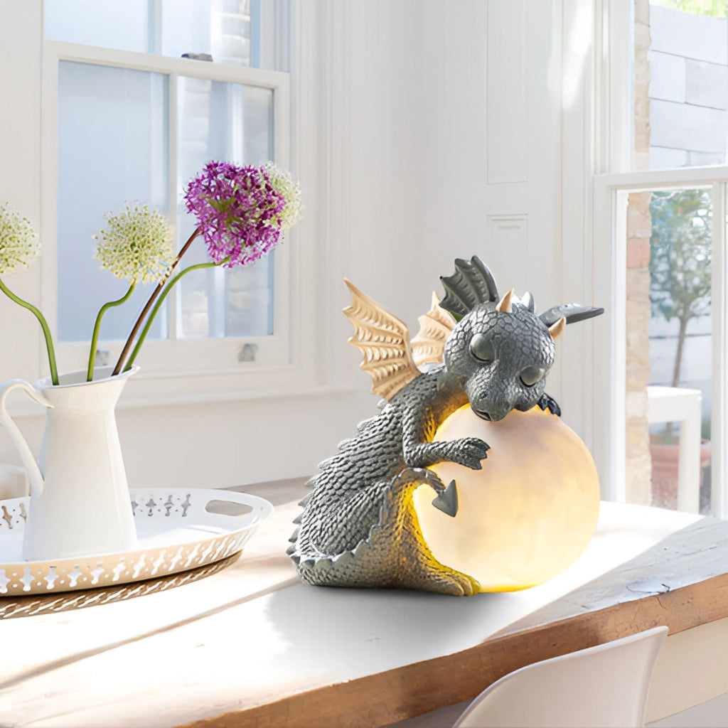 Dragon Shaped LED Table Lamp on a desk near a window with flowers and plants in the background.