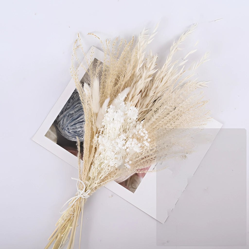 30-piece set of dried pampas grass flowers in various natural shades, arranged aesthetically with twigs and wooden elements for interior decoration.