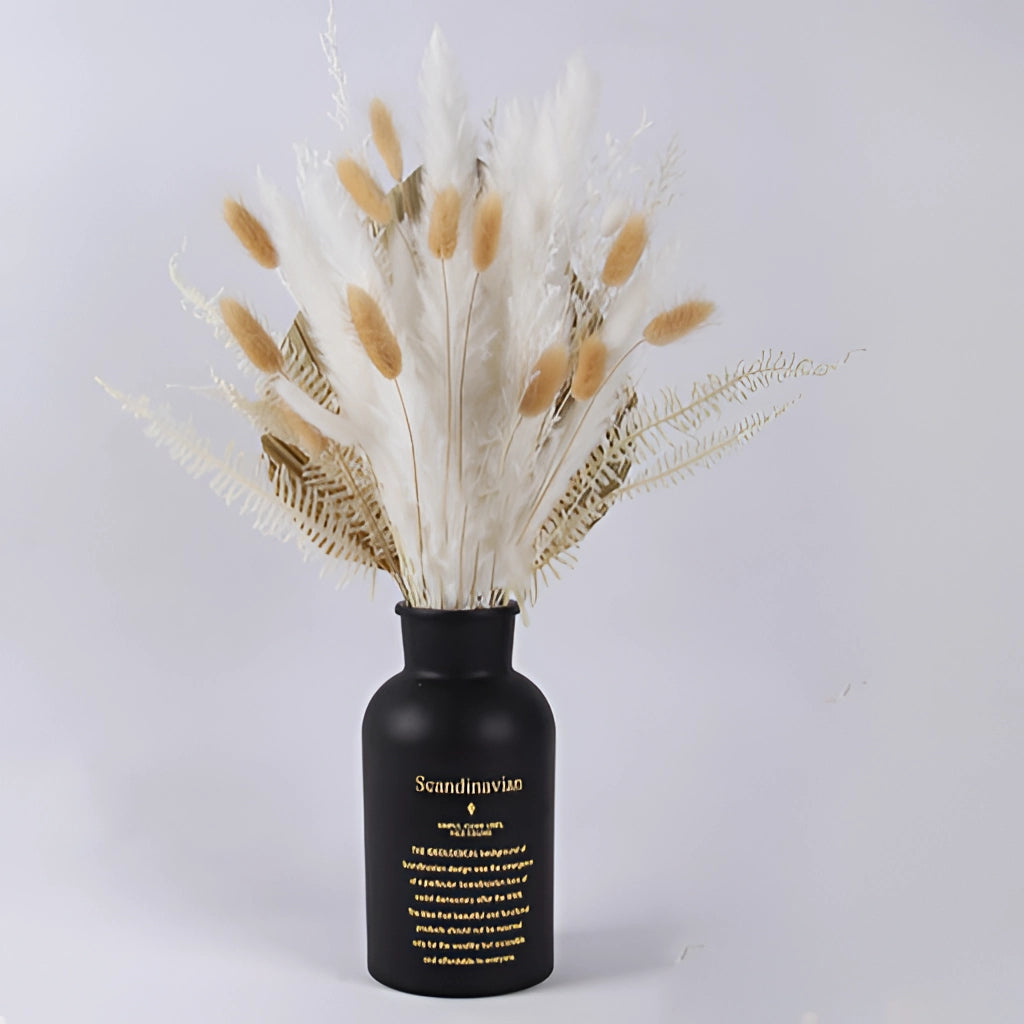 A set of dried pampas grass flowers arranged in a clear glass vase, perfect for interior decoration.