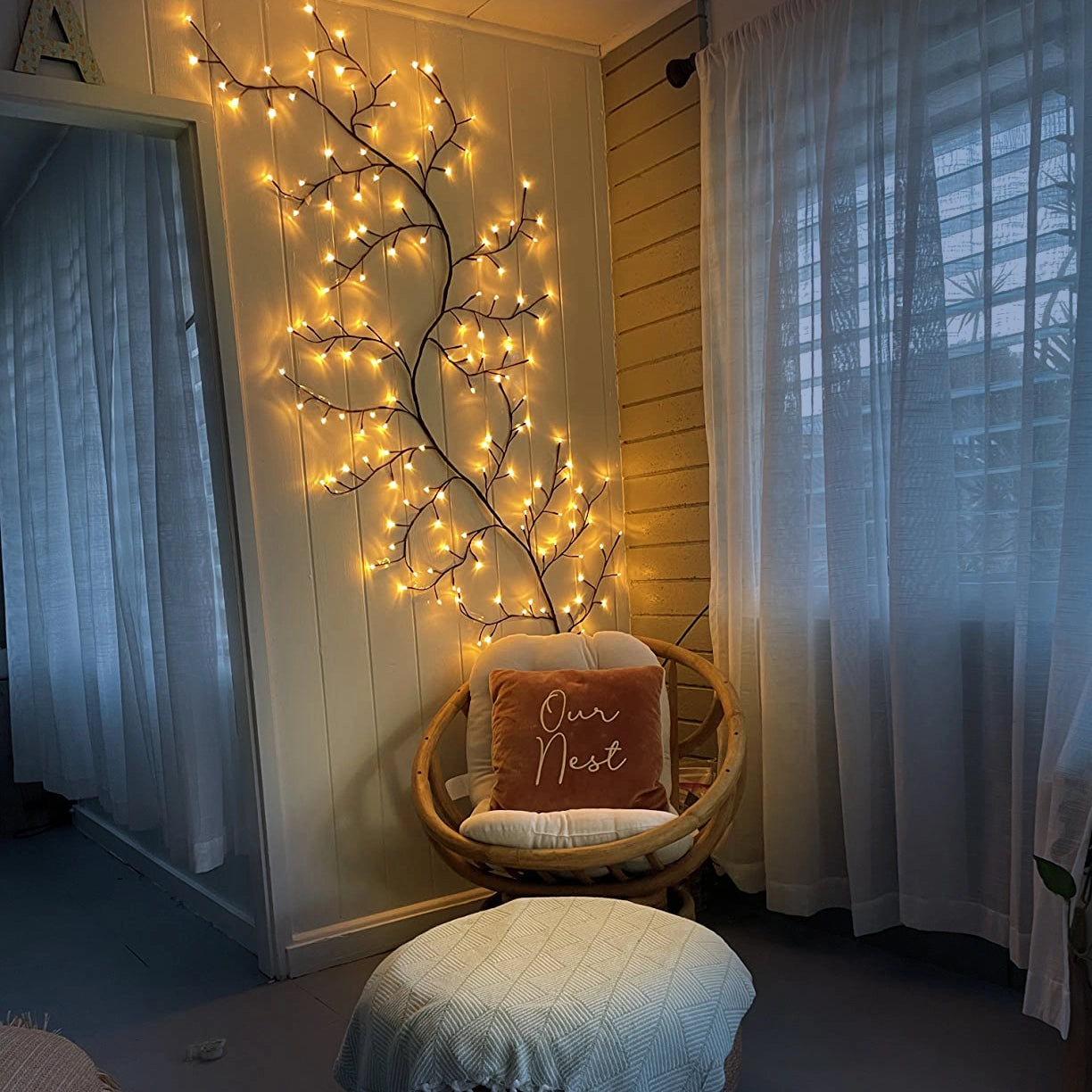Enchanted Willow Vine Light Freya illuminating a tranquil interior space with elegant wood and textile decorations, featuring curtains and a well-designed flooring.