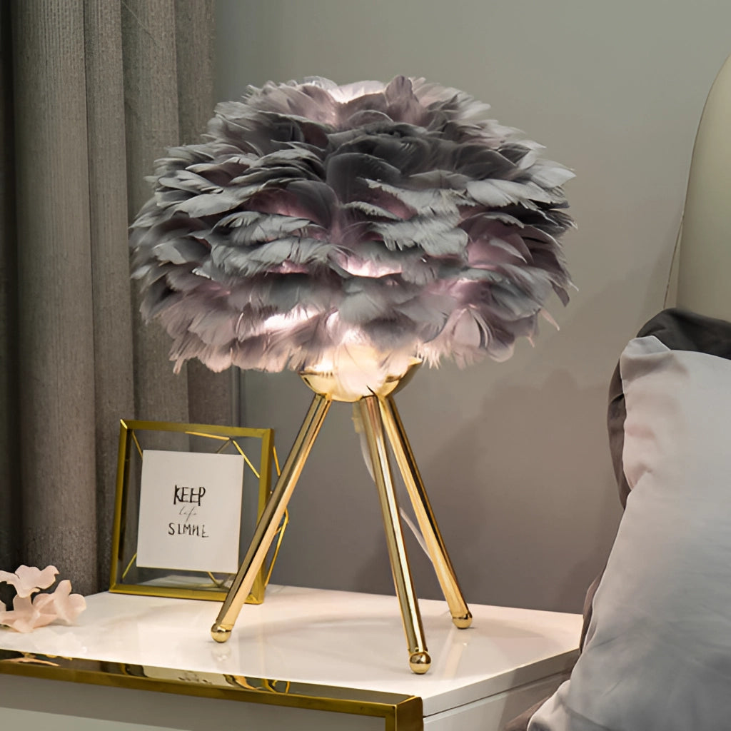 Feather LED Table Lamp with dimmable lighting on a table next to a vase with white flowers and a picture frame.