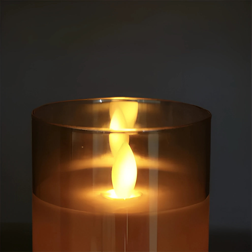 Three-piece LED flameless glass candle set with remote control, featuring realistic amber flame-like glow, cylindrical wax pillars.
