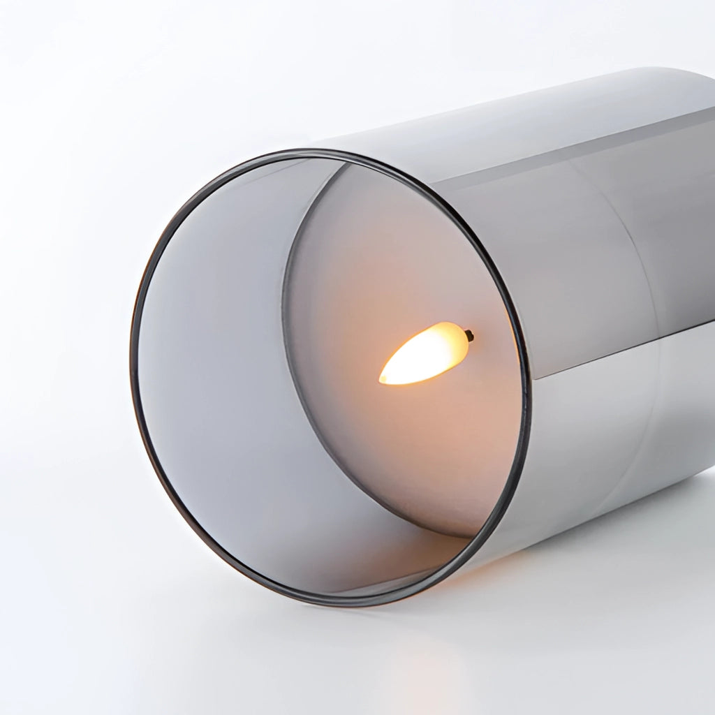 A set of three flameless glass pillar candles with a remote control, emitting a warm LED glow.