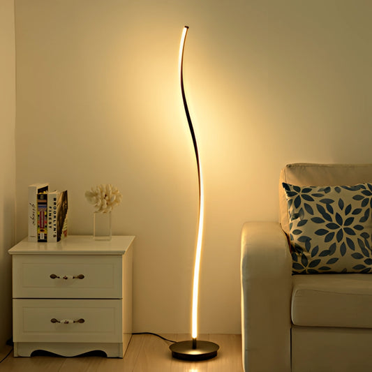 A stylish floor lamp with a remote control featuring three adjustable light temperatures, shown in a modern living room setting with wooden furniture and a cozy table nearby.