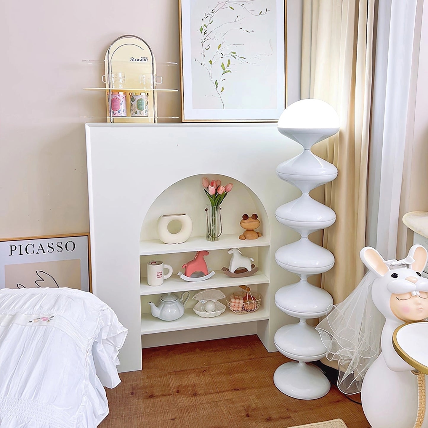 Modern floor lamp with twisted gourd design in white, placed in a stylish interior with wooden shelves, dishware, curtains, and a peach-colored decor.