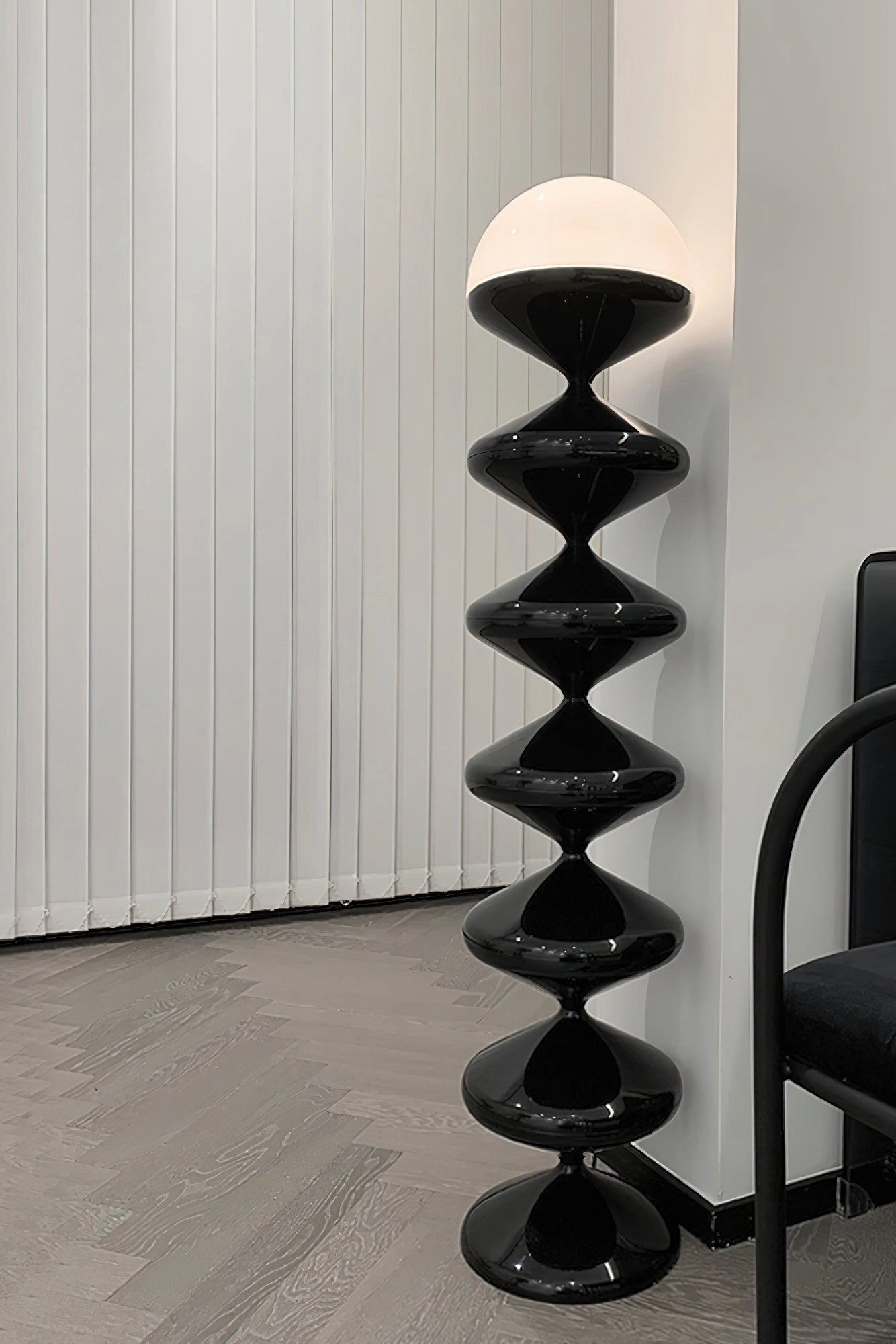 Modern floor lamp with twisted gourd design next to a wooden shelf and hardwood flooring in an elegant, contemporary living space.