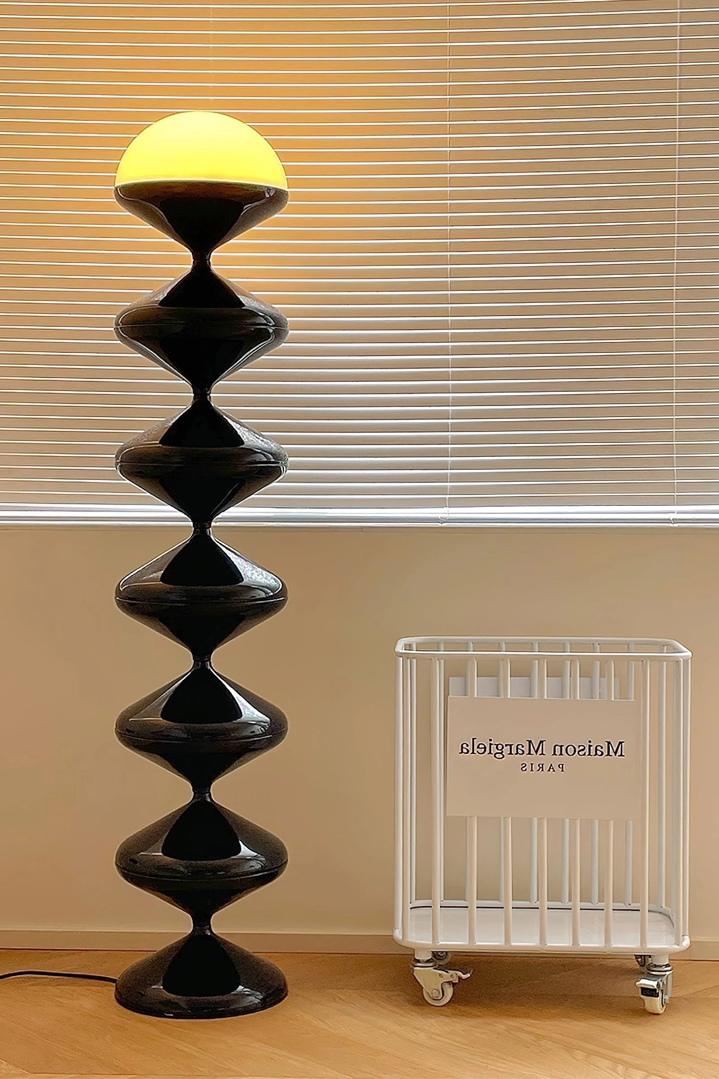 Modern floor lamp with twisted gourd design, featuring an elegant shade, placed beside a wooden shelf.