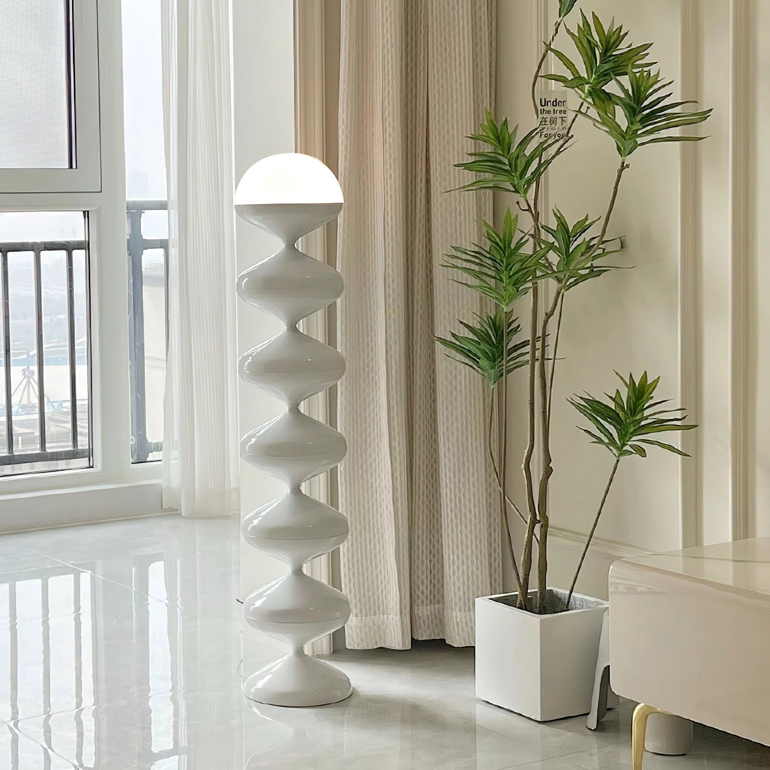Modern elegant floor lamp with twisted gourd design next to a wooden side table, houseplant, and large window in a stylish interior setting.