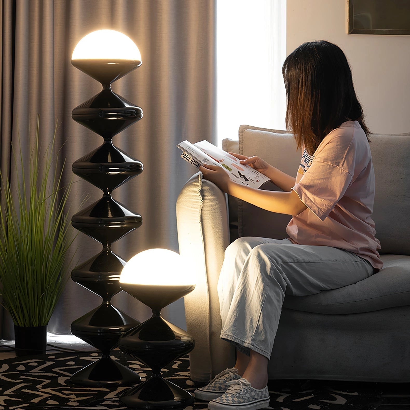 A modern floor lamp with a twisted gourd design, providing elegant lighting in a cozy interior setting with a book and plant nearby.
