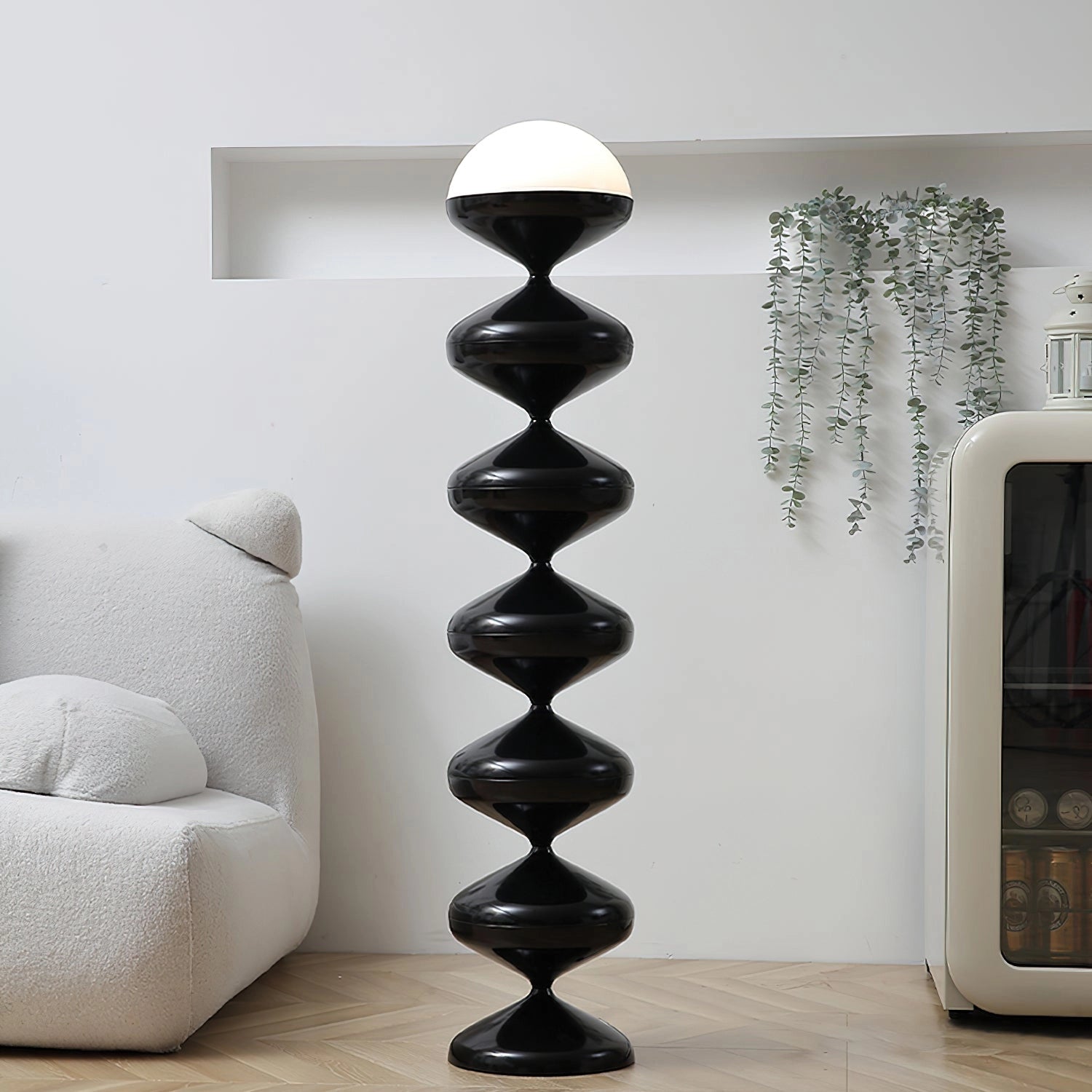 Modern floor lamp with twisted gourd design, positioned in a stylish interior with wooden shelving and grey walls.