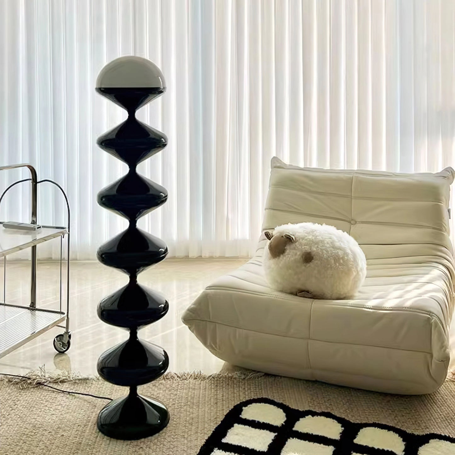 Modern elegant floor lamp with twisted gourd design, featuring a white shade and wooden base, placed in a stylish interior setting with grey flooring.