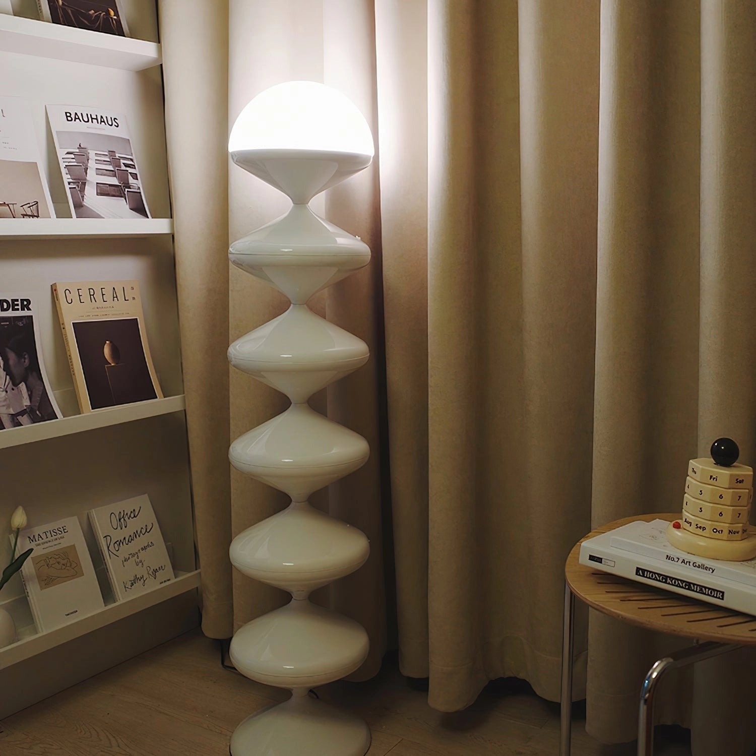 Modern elegant floor lamp with twisted gourd design, featuring a wooden base, set in a beige interior with hardwood flooring.