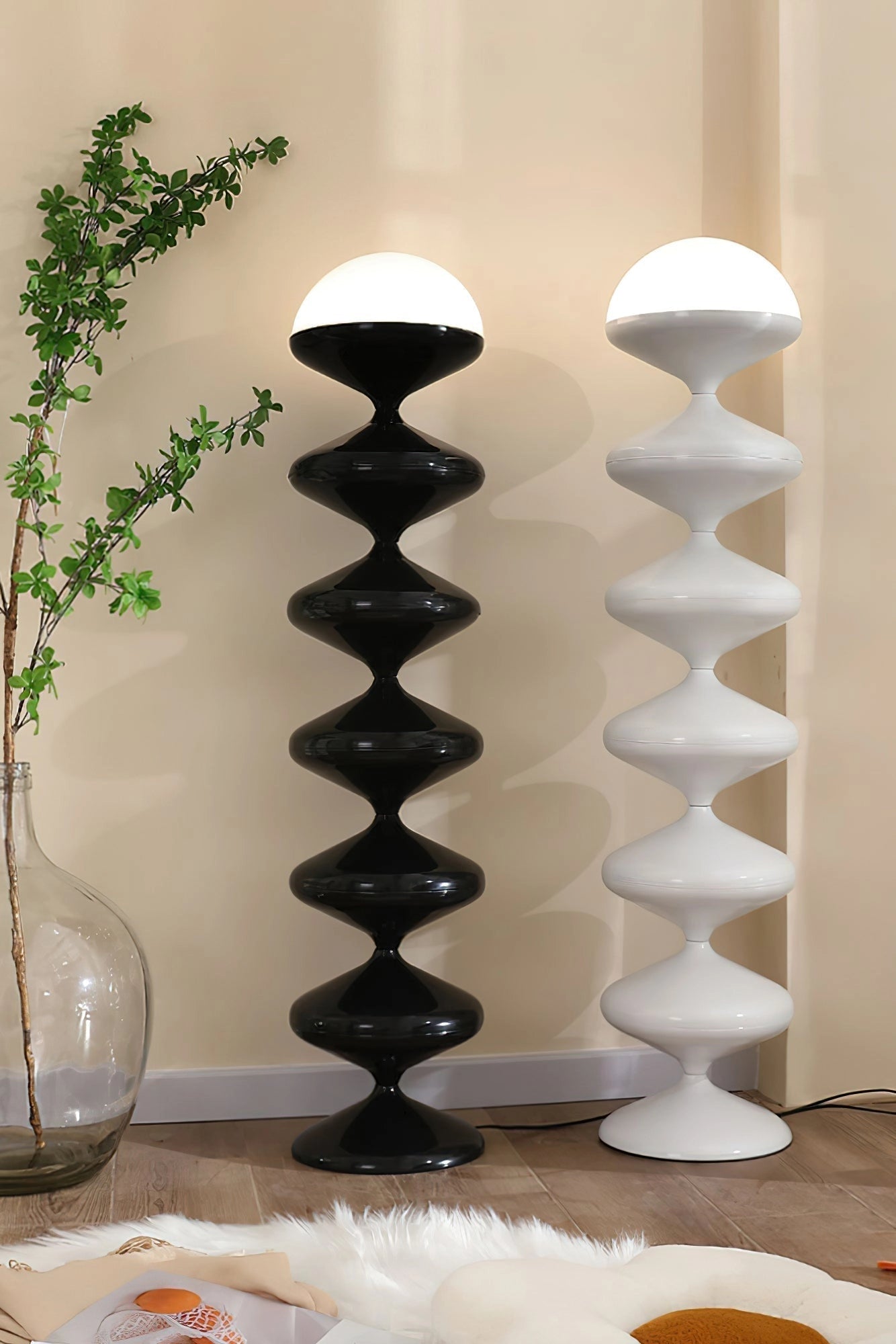 Modern elegant floor lamp with twisted gourd design placed in a stylish interior setting featuring houseplants, wooden shelves, and decorative tableware.