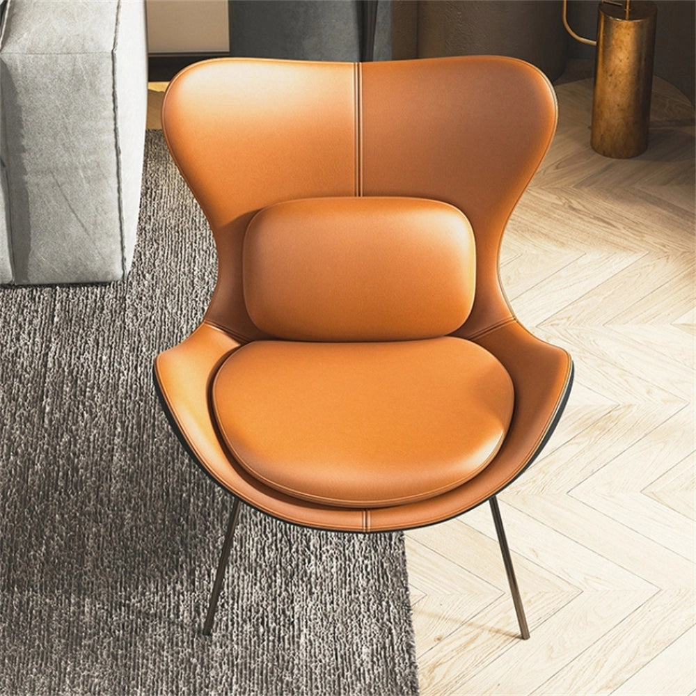 A modern geometric accent chair with an orange cushioned seat, wooden legs, and rectangular armrests on a wood-floored living room.