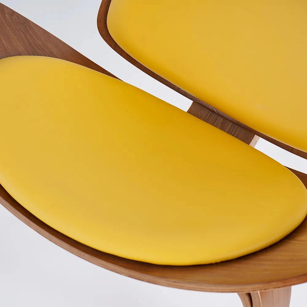 A modern geometric retro accent chair placed in a contemporary space, surrounded by a wooden table set with dishware, plates, and kitchen utensils.