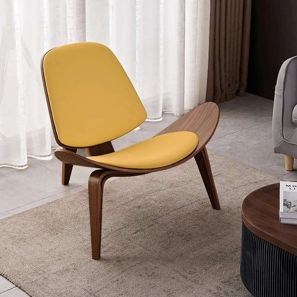 Yellow geometric retro accent chair with wooden legs, placed in a modern interior setting with hardwood flooring.