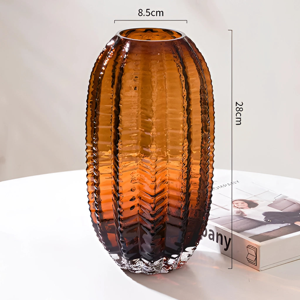 Large brown glass cactus vase with an amber hue, resembling an artistic pottery artifact, placed on a wooden surface.