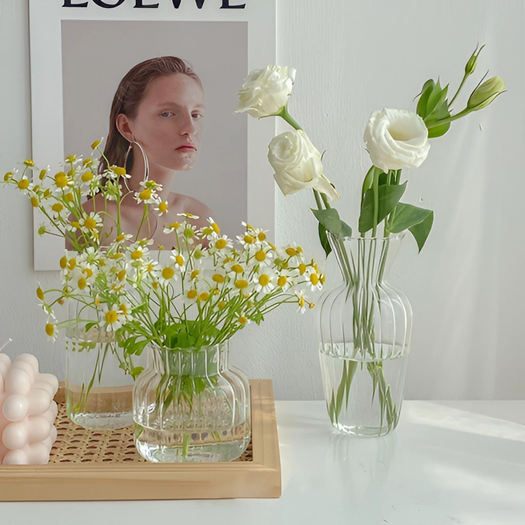 Nordic style transparent glass plant vase with a floral arrangement, featuring various flowers and lush green plants.