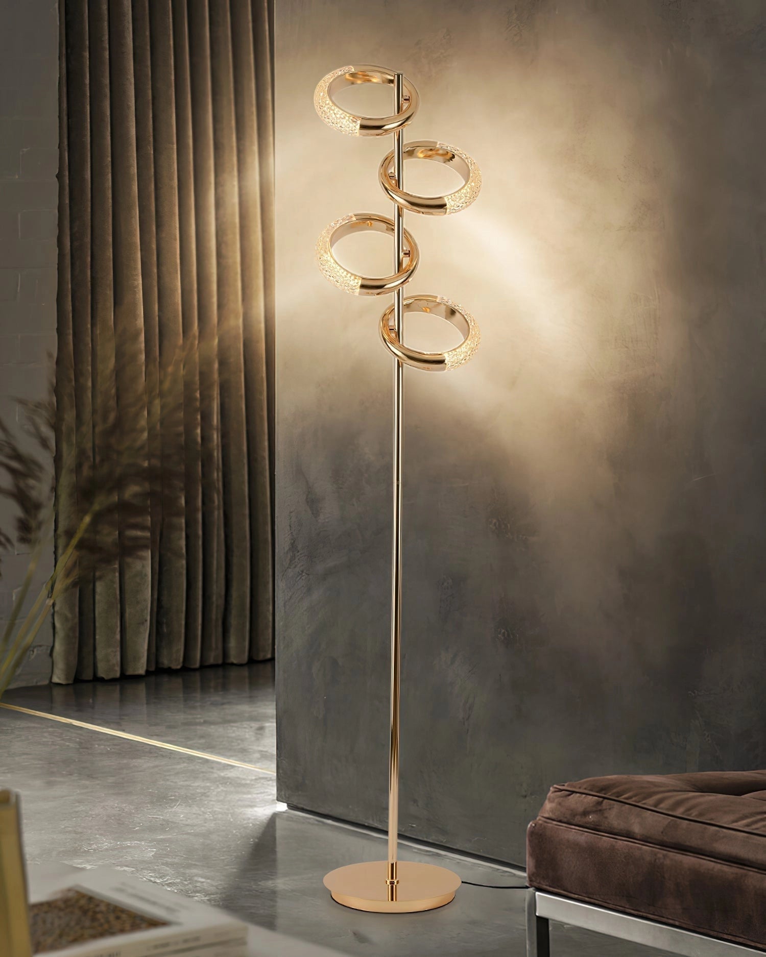 Gold diamond-patterned adjustable angles floor lamp with a wooden base, positioned on a hardwood floor next to a small table with plant decor and a glass vase, under a ceiling with warm lighting.
