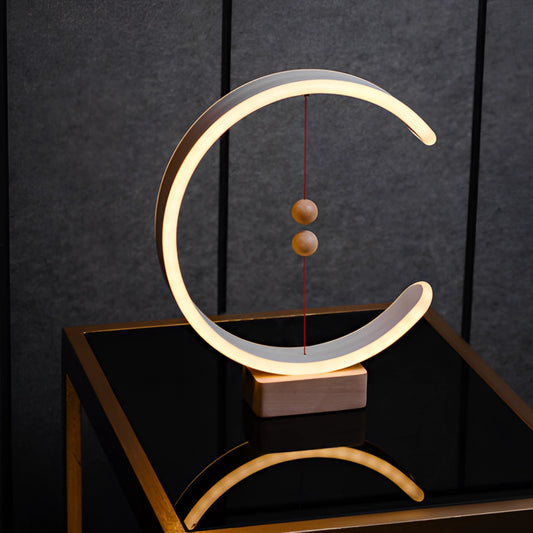 Interior lamp with magnetic switches, featuring a crescent-shaped glow, wooden rectangular base, and metal accents.