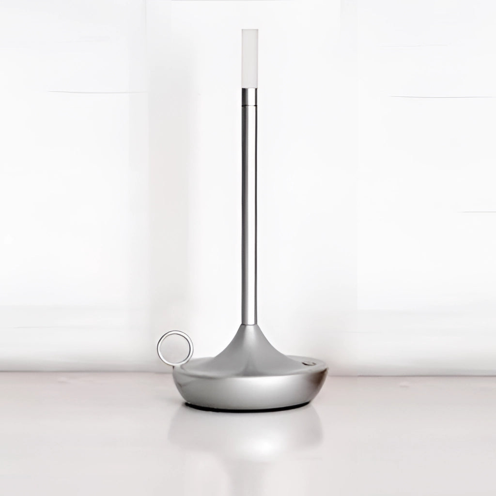 A silver iron lamp with a unique candle design, featuring a 3-level dimming option, displayed on a table in a stylish interior setting.