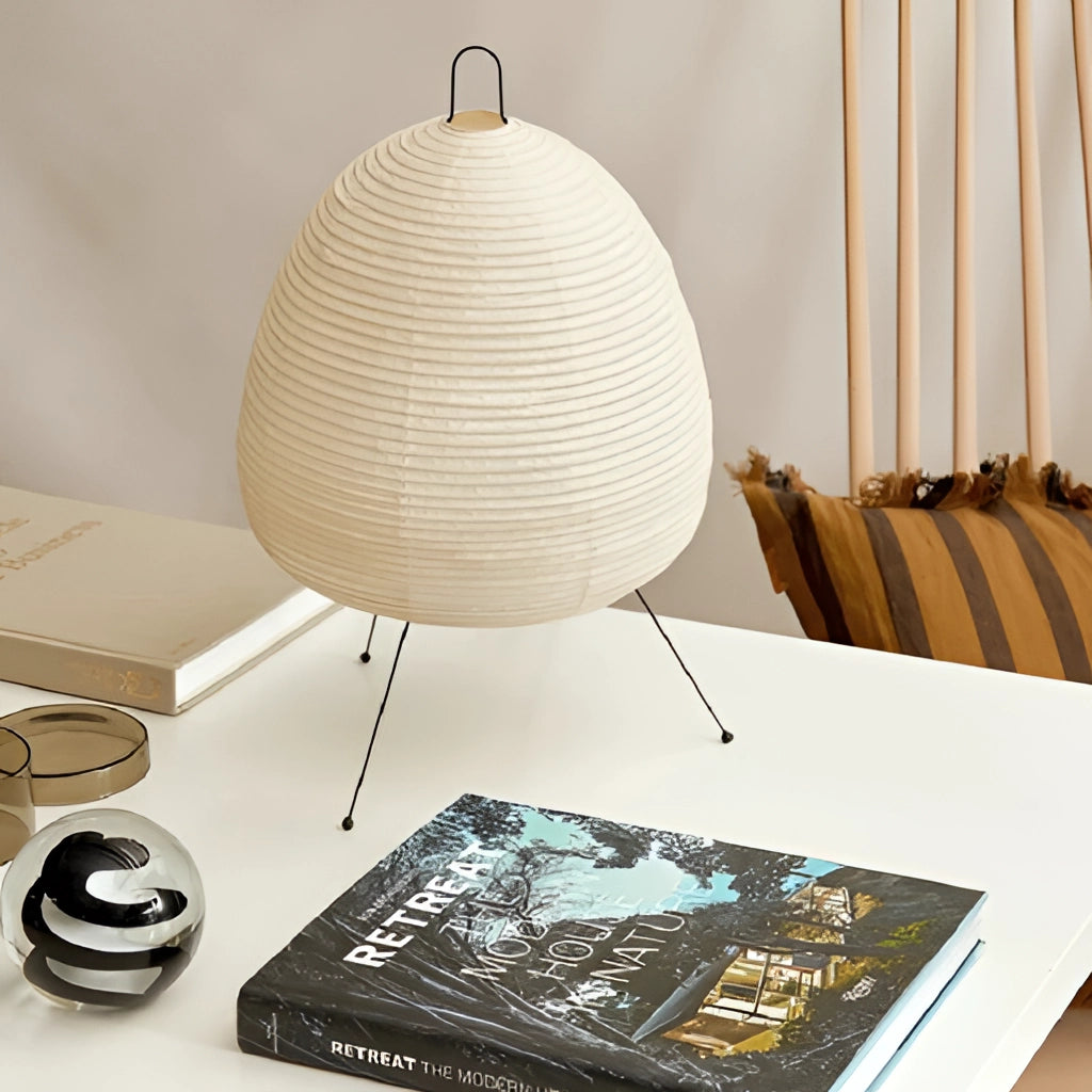 Japanese Rice Paper Table Lamp on a wooden table, emitting a soft glow; perfect for enhancing interior design with a blend of traditional and modern aesthetics.