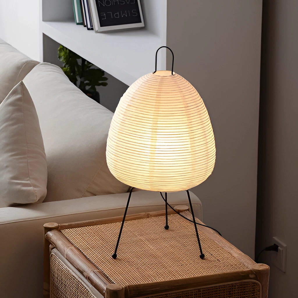 Japanese rice paper table lamp with wooden accents, beige shade, illuminating a cozy interior setting.