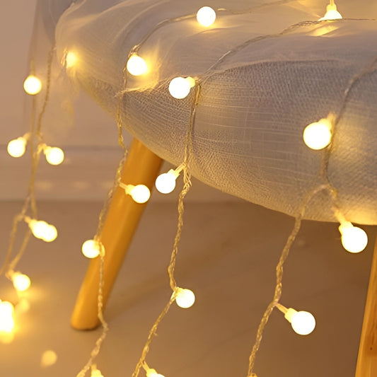 Warm white LED fairy string lights with 100 ball-shaped bulbs, creating a twinkling effect and a romantic ambiance, hanging from a wooden ceiling.