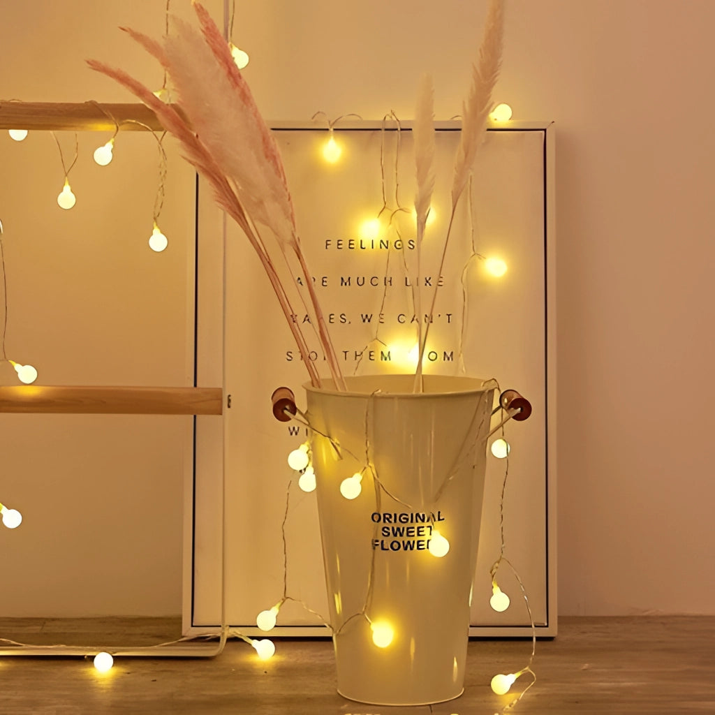 LED Fairy String Lights creating a warm, amber glow in a cozy interior setting with wooden and glass elements, enhancing the romantic ambiance.