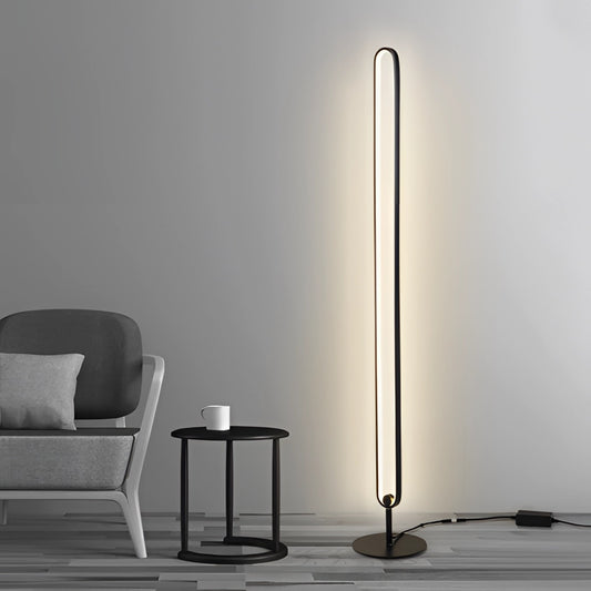 LED floor lamp with a stylish design featuring RGB multicolor and warm white lighting, placed on wooden flooring next to a chair.