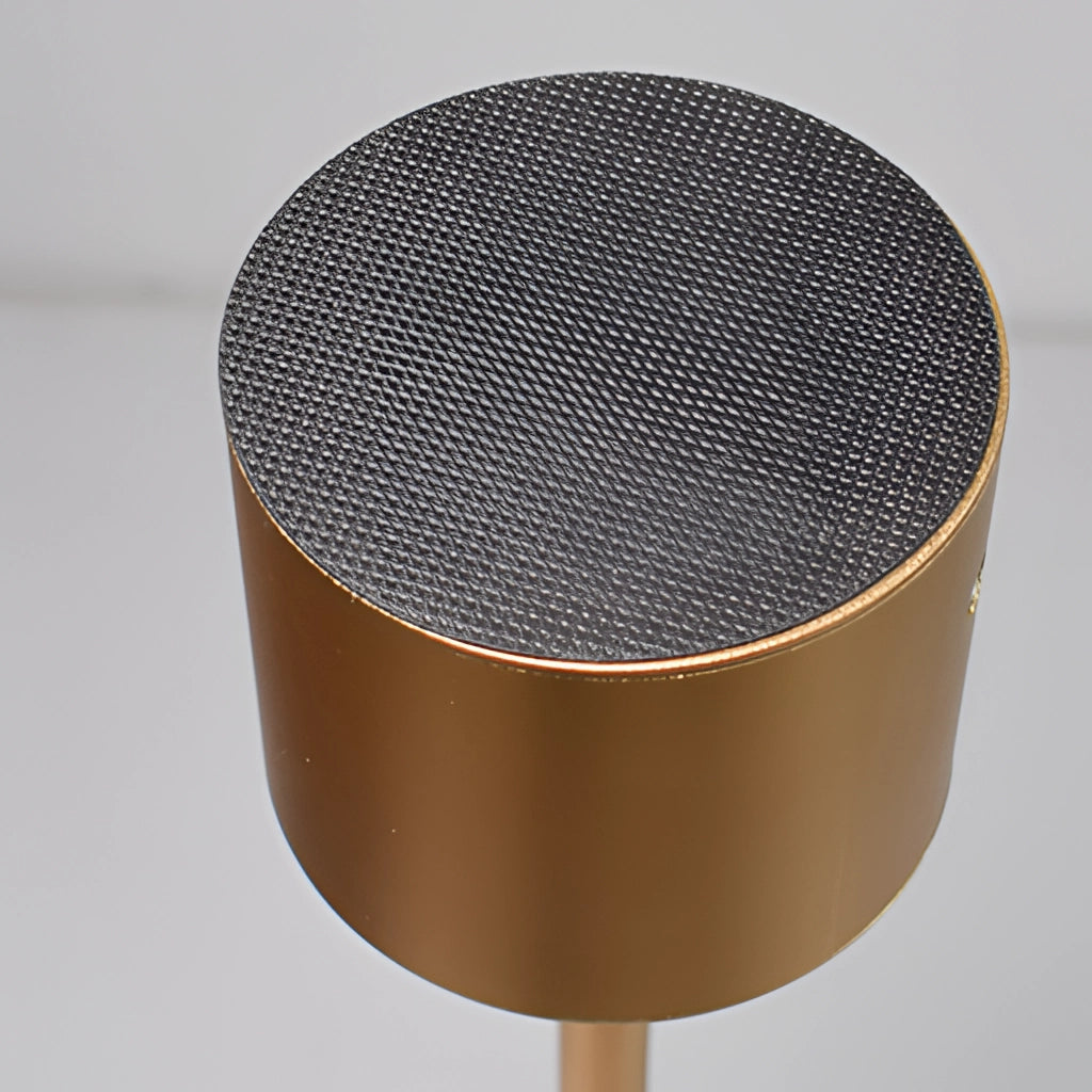 LED Portable Table Lamp with Resilient Design on a wooden table, featuring a cylindrical shape with a grille pattern.
