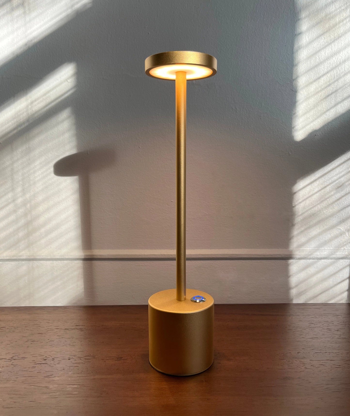 LED Portable Table Lamp with a wood base and sleek design, emitting soft lighting on a hardwood floor.