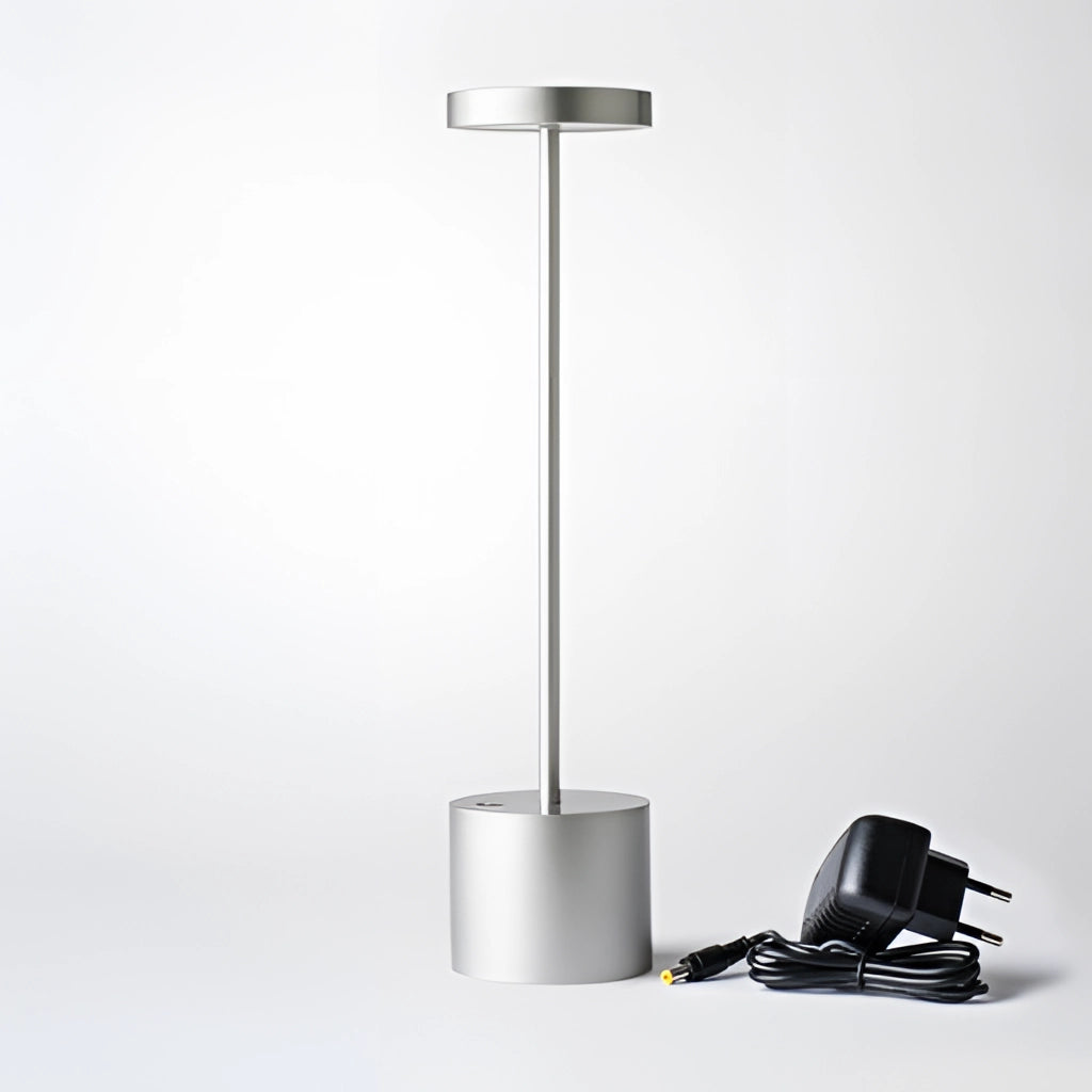 Silver LED Portable Table Lamp with Resilient Design placed on a table.