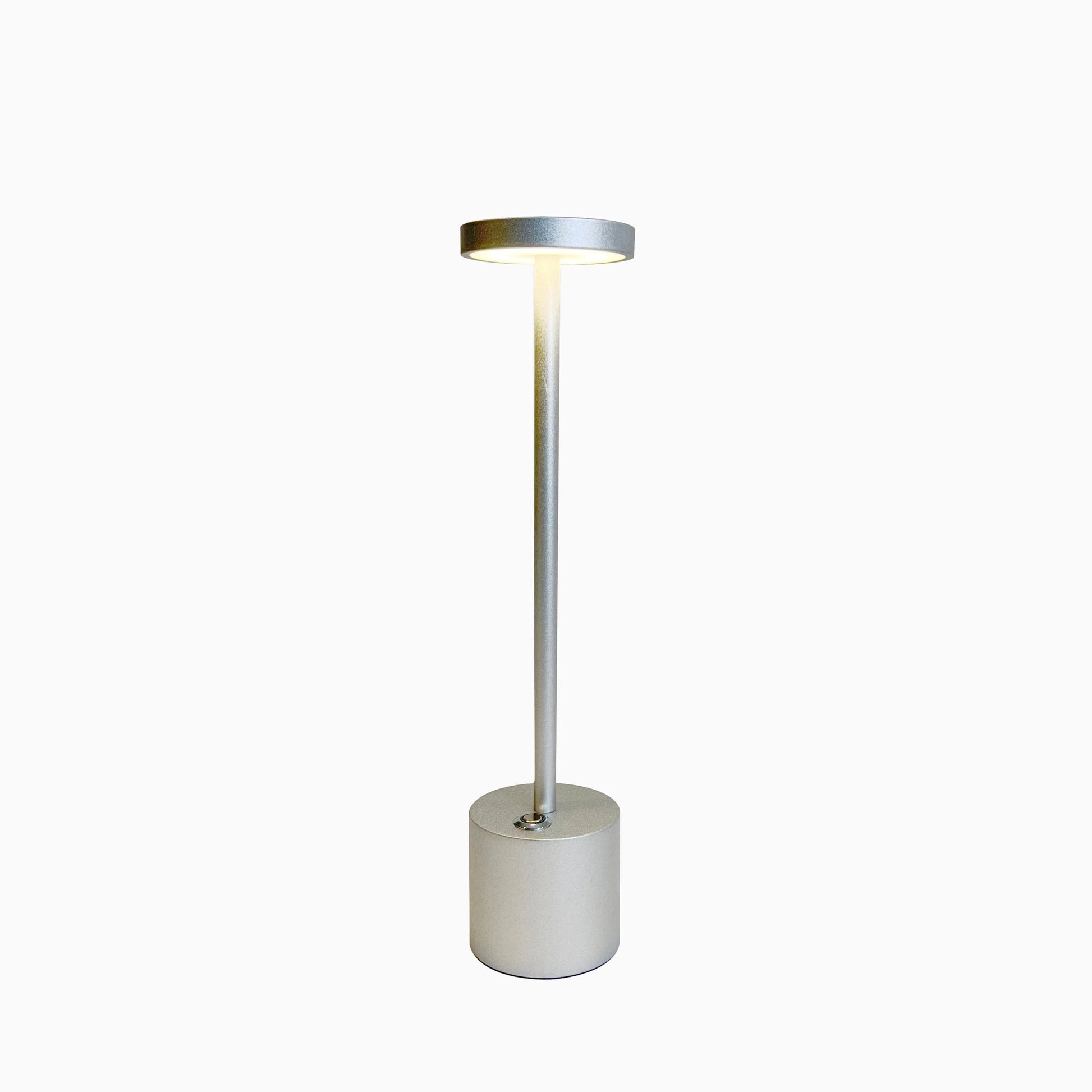 LED Portable Table Lamp with resilient design featuring a sleek cylindrical shape, nickel finish, and a transparent glass shade.