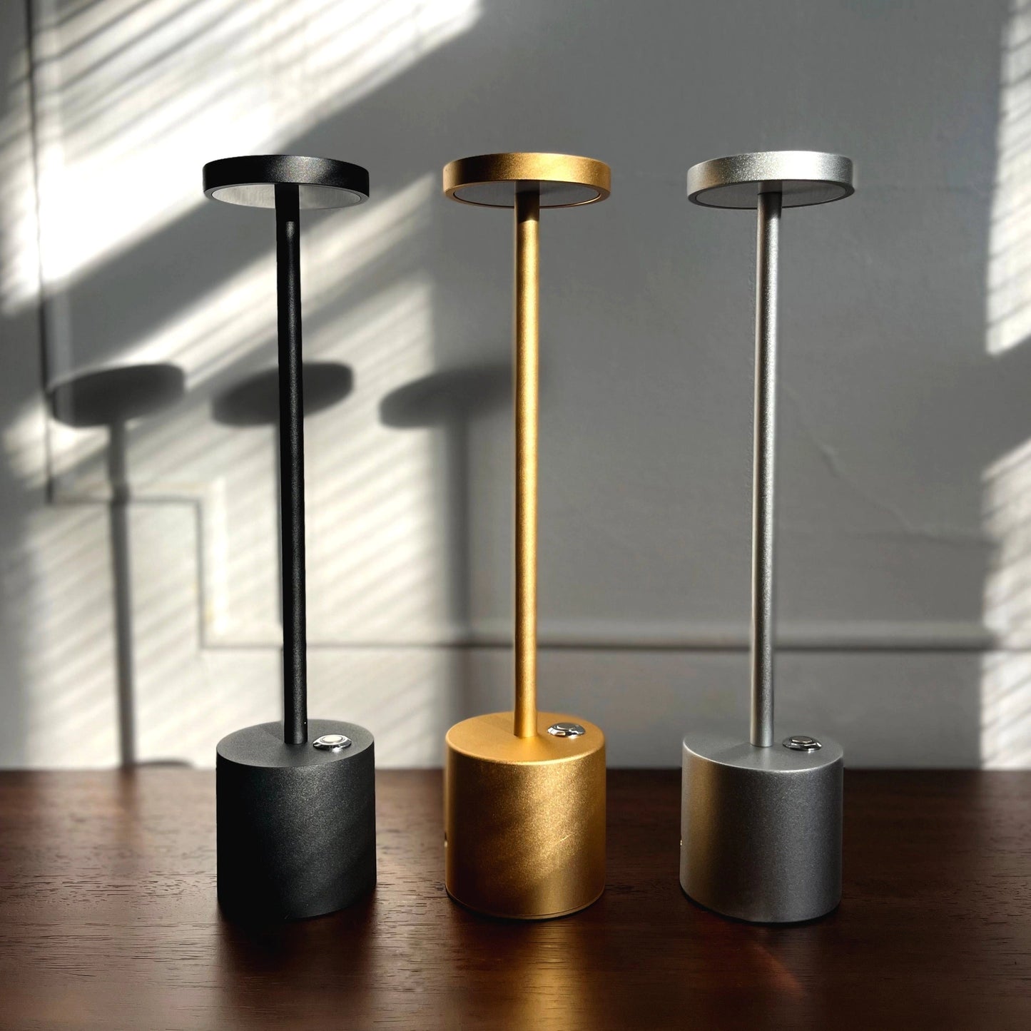 LED Portable Table Lamp with Resilient Design, featuring a cylindrical metal body, wooden base, and an artistic, minimalist style.