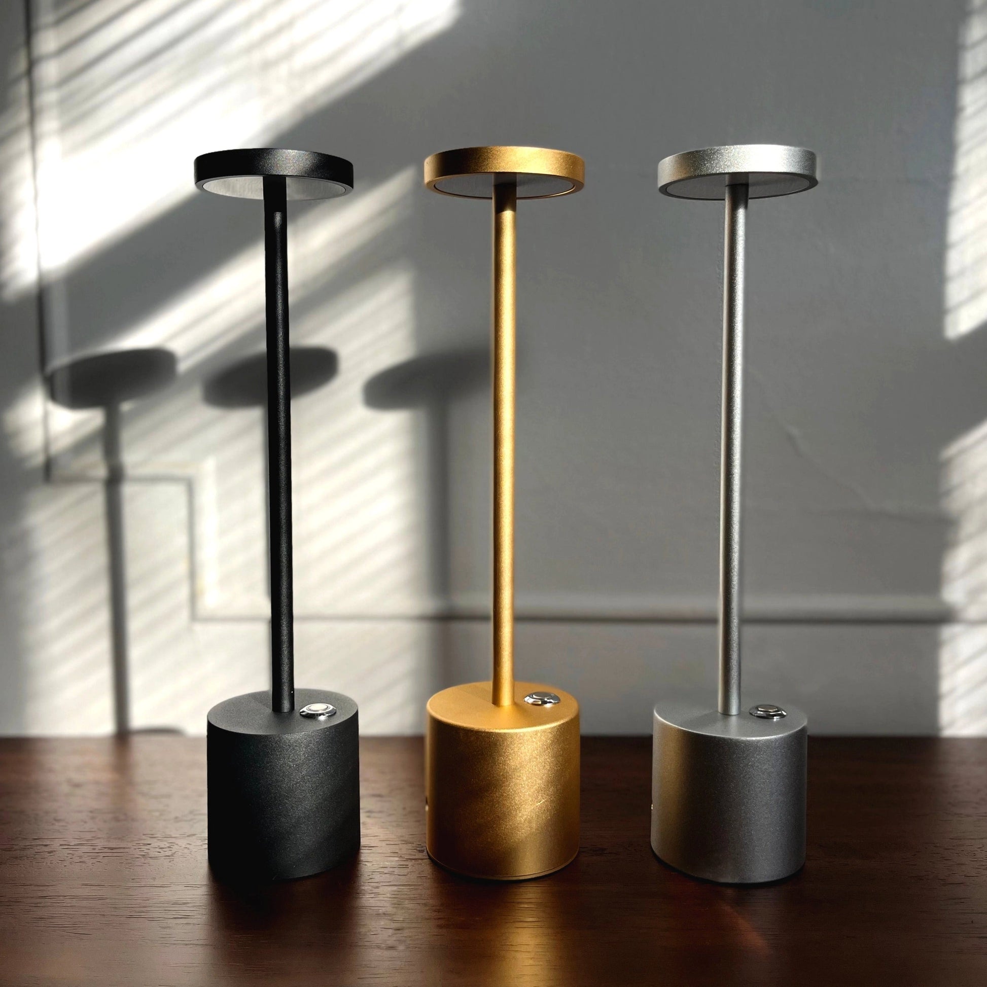 LED Portable Table Lamp with Resilient Design, featuring a cylindrical metal body, wooden base, and an artistic, minimalist style.