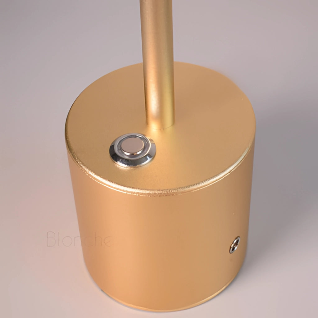 LED Portable Table Lamp with Resilient Design, cylindrical shape, metallic finish, placed on a kitchen countertop.