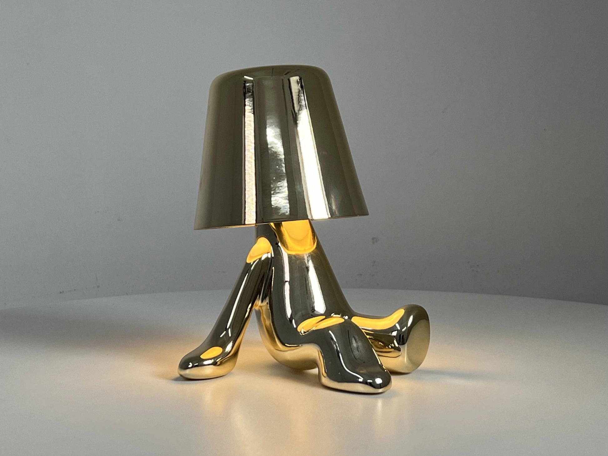 LED table lamp with unique design on a table next to a glass of water.