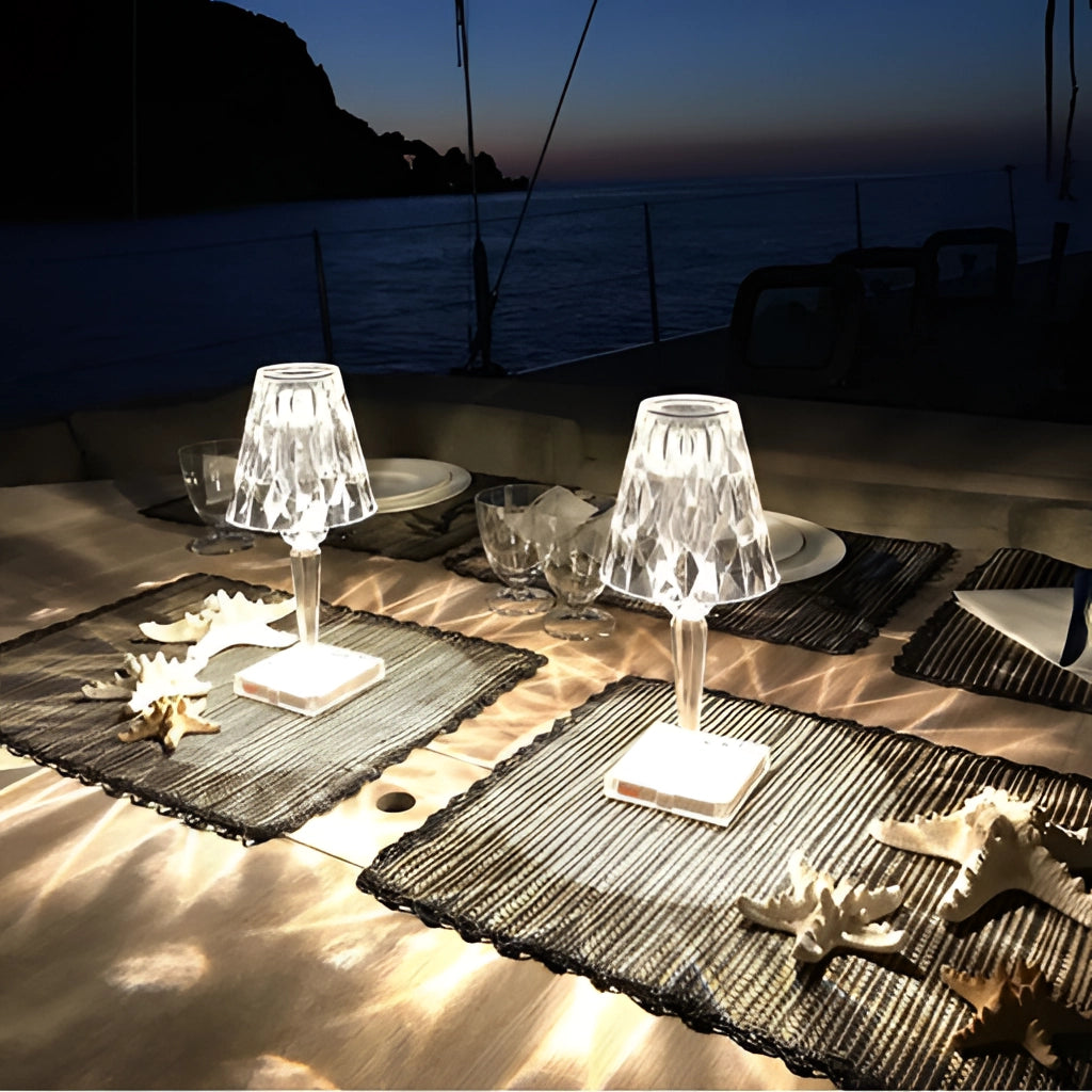 LED touch table lamp with USB charging on a wooden surface, emitting soft light in a serene, nautical-themed setting.