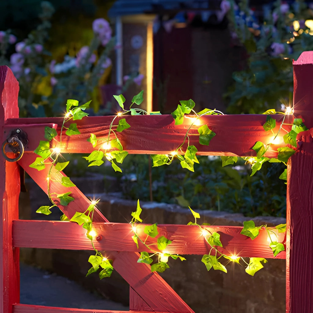 LED vine garden string lights with ivy vines, 32ft length with 100 LEDs, illuminating a dark background, showcasing decorative ivy leaves and vibrant lights.