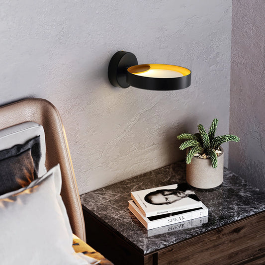 LED wall light with artistic design mounted on a grey wall, illuminating an interior space with a houseplant and flowerpot nearby, adding comfort and elegance to the living room.