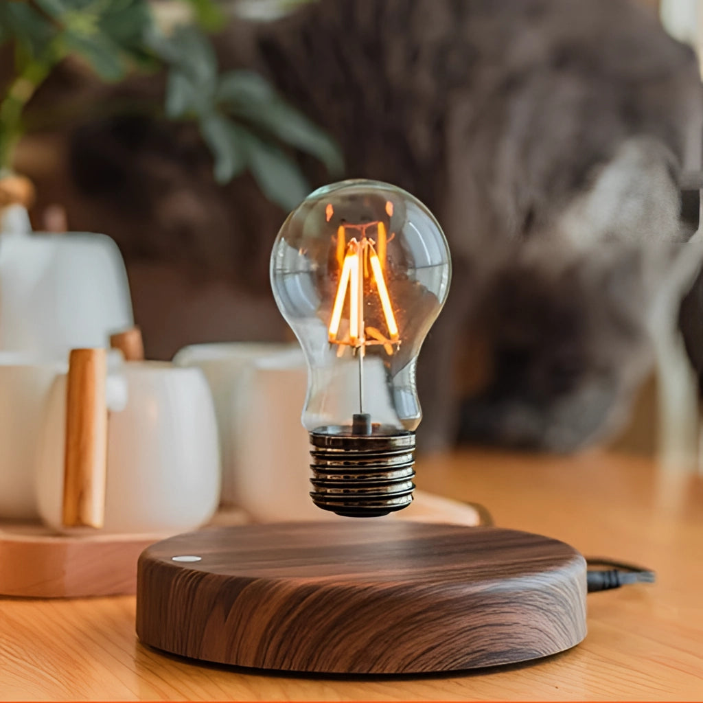 Levitating LED desk lamp with walnut base in circle variant on a wooden table, next to a plant.
