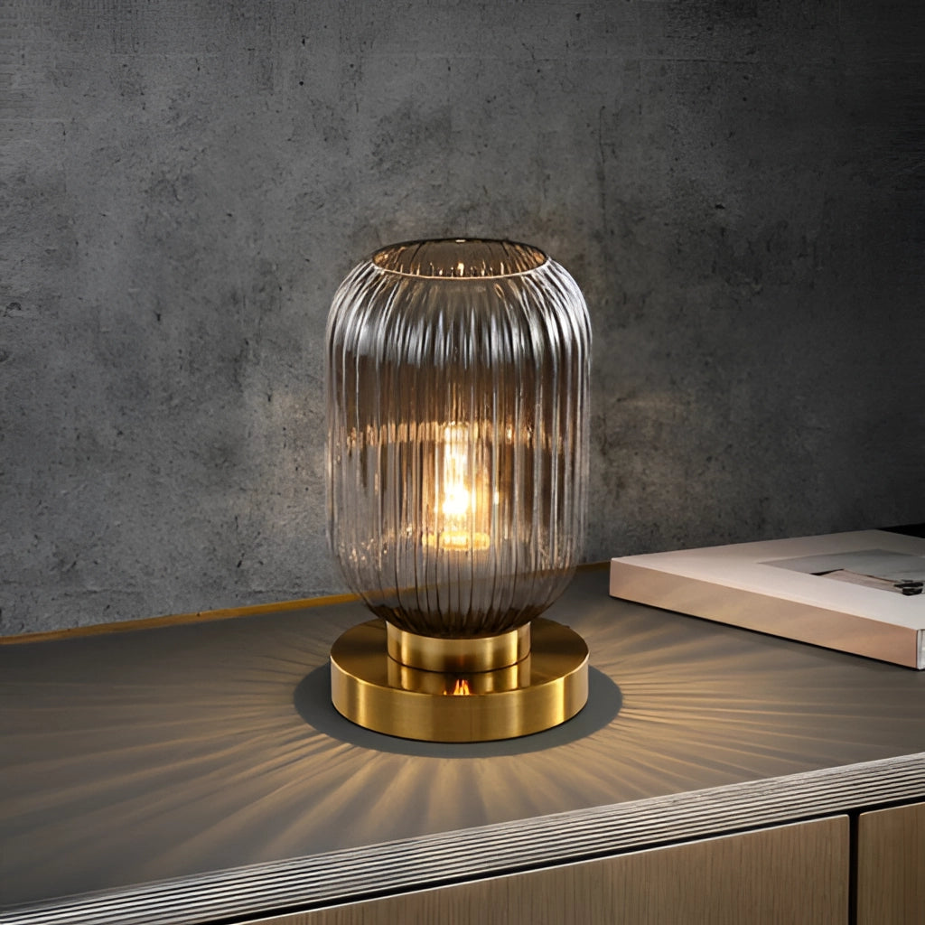 A luminescent crystal table lamp with a wooden base and metal accents, featuring an artistic glass sculpture under a glowing light fixture.